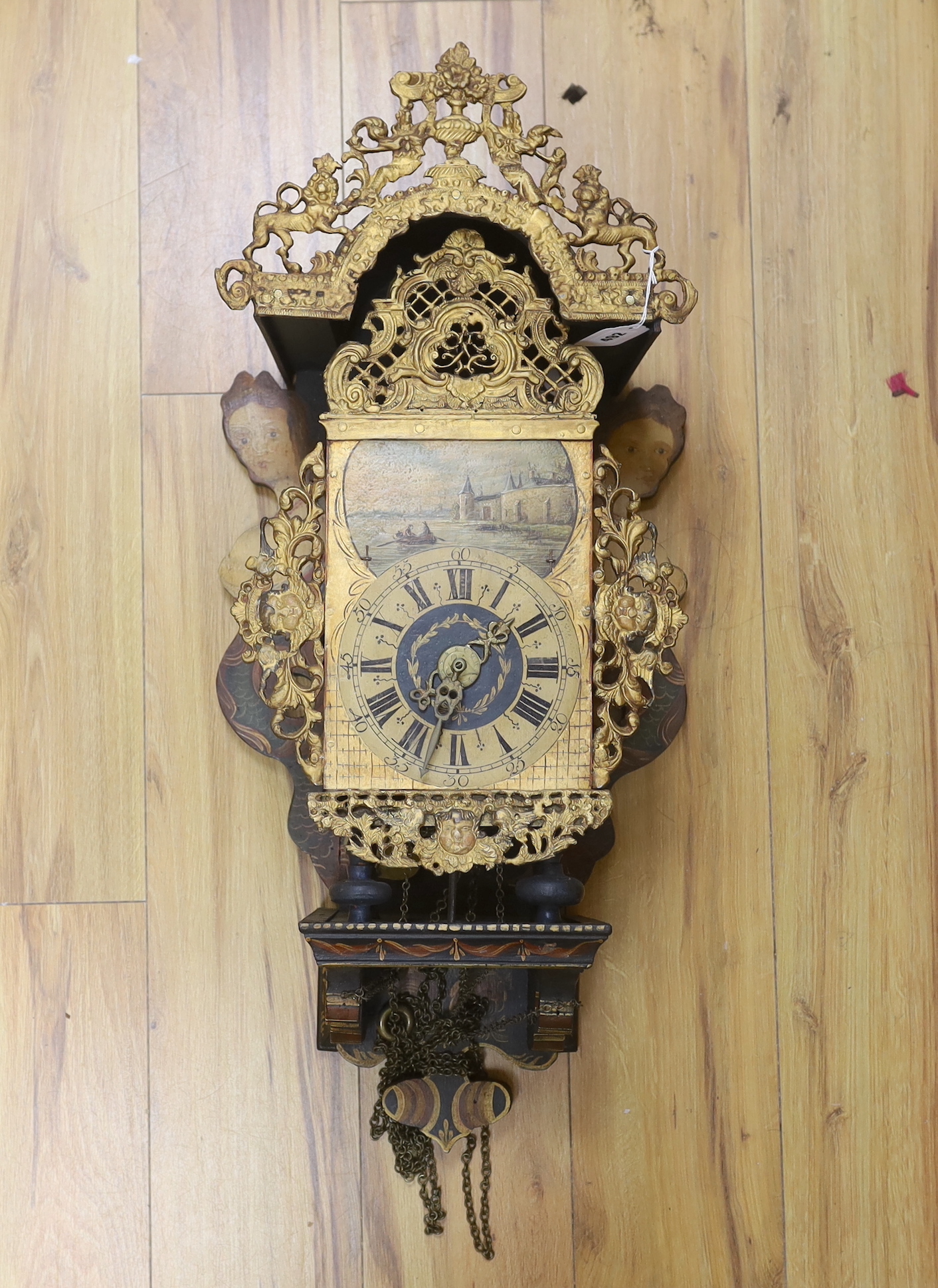 A decorative Dutch wall clock, with shaped painted mermaid side panels,72cm high